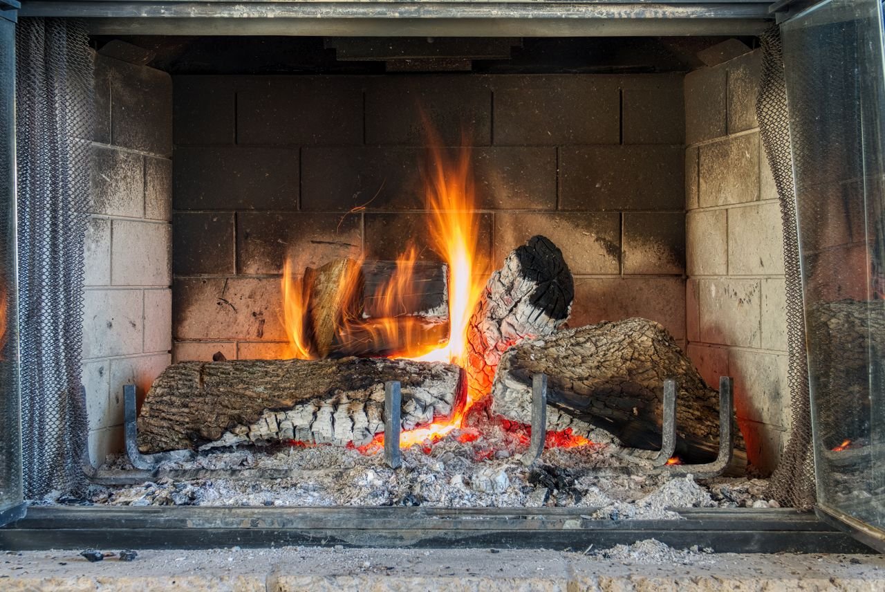 hero-02 A warm and inviting close-up of a crackling wood-burning fireplace.